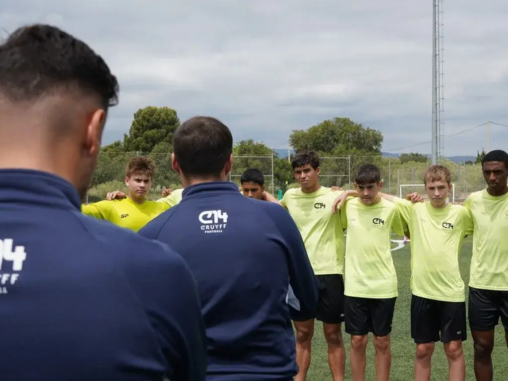 Soccer team huddles during a training session.